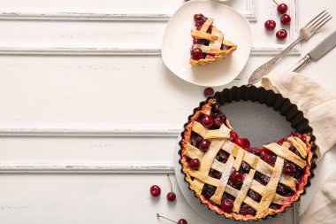 Lezzetli vişneli turta ve beyaz arka planda bir tabak yemek.