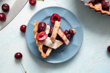 Mavi arka planda bir dilim lezzetli vişneli turta.