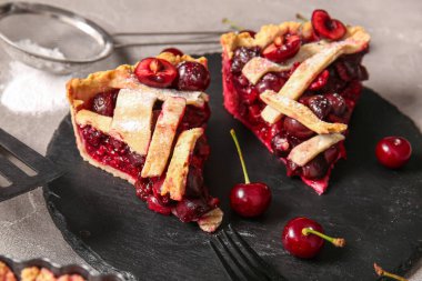 Gri arka planda lezzetli vişneli turta parçaları olan tahta