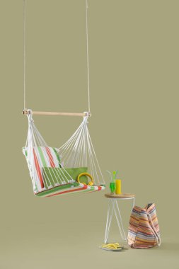 Hamak, plaj aksesuarları ve yeşil arka planda tabureye kokteyl asmak. Seyahat kavramı