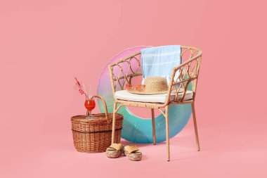 Sandalyeli kompozisyon, hasır sepet, plaj aksesuarları ve pembe arka planda kokteyl. Seyahat kavramı