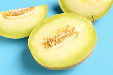 Mavi arka planda parçalı tatlı kavunun yarısı