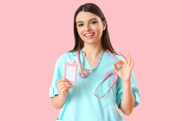 Medizinische Praktikantin Mit Abzeichen Das Auf Rosa Hintergrund Zeigt — Stockfoto