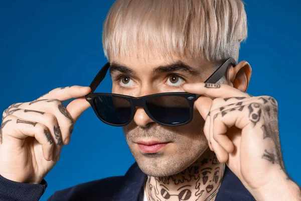 Ung Tatuerad Man Solglasögon Blå Bakgrund Närbild — Stockfoto