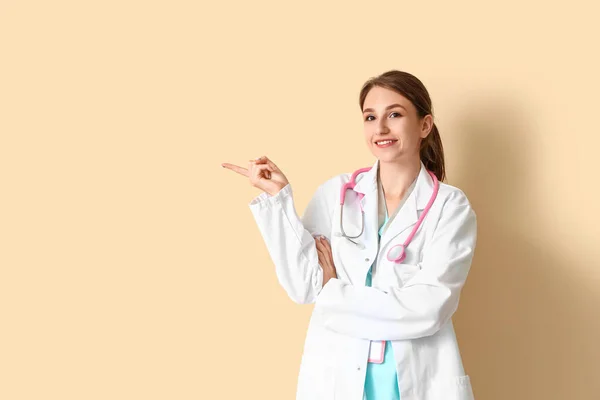 Žena Lékařské Stážistka Ukazuje Něco Béžovém Pozadí — Stock fotografie