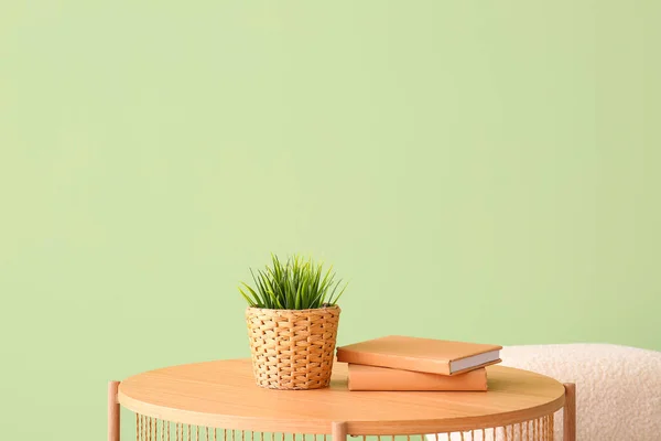 緑の壁の近くの観葉植物 本やPouffと木製のコーヒーテーブル — ストック写真