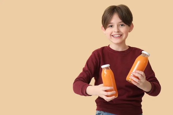 Mały Chłopiec Butelkami Soku Pomarańczowego Beżowym Tle — Zdjęcie stockowe