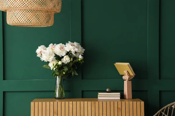 緑の壁の近くのドレッサーとランプ付きの白い牡丹の花瓶 — ストック写真