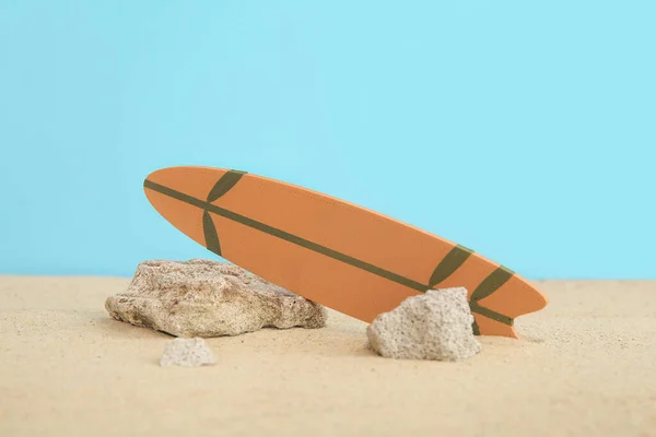 Mini Surfbrett Mit Steinen Auf Sand Vor Blauem Hintergrund — Stockfoto