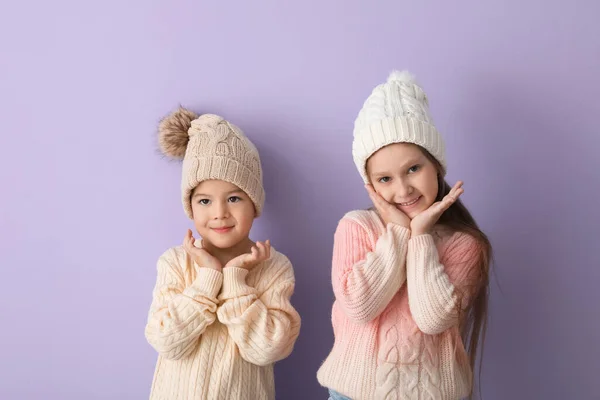 라일락 배경에는 모자를 스웨터를 어린이들을 귀여워 — 스톡 사진