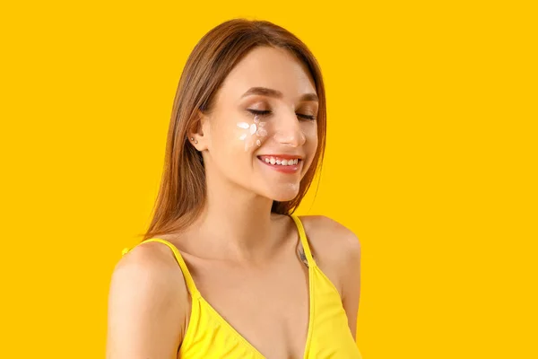 黄色の背景に日焼け止めクリームを持つ若い女性 クローズアップ — ストック写真