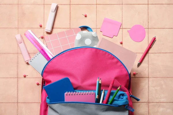 ピンクスクールバックパックノートブック 鉛筆やベージュタイルの背景のマーカー — ストック写真