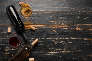 Şişe ve kadehler koyu ahşap arka planda nefis şaraplar.