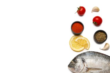 Beyaz arka planda malzemeli çiğ dorado balığı.