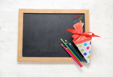 Beyaz arka planda farklı kırtasiye malzemesi ve tahtası olan kırmızı okul konisi