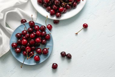 Mavi arka planda tatlı kirazlı tabaklar