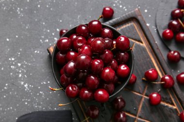 Siyah masada kirazlı kase ve yemek.