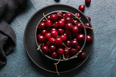 Koyu renkli masada kirazlı kase