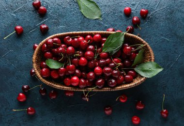 Mavi arka planda kirazlı hasır kase.