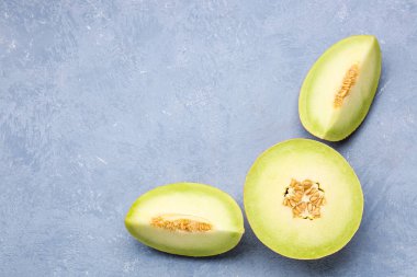 Mavi arka planda parçalı tatlı kavunun yarısı