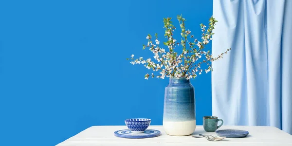 Ваза Гілками Квітучого Дерева Посудом Білому Столі Синьому Фоні Банер — стокове фото
