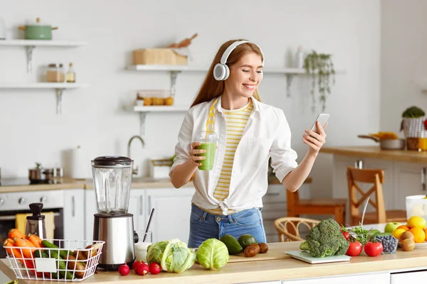 Junge Frau Mit Kopfhörer Und Gesundem Smoothie Und Handy Hause — Stockfoto