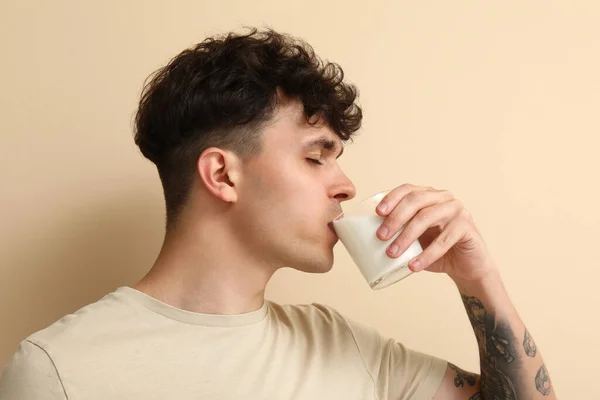 Young Man Drinking Milk Beige Background Closeup — Stock Photo, Image