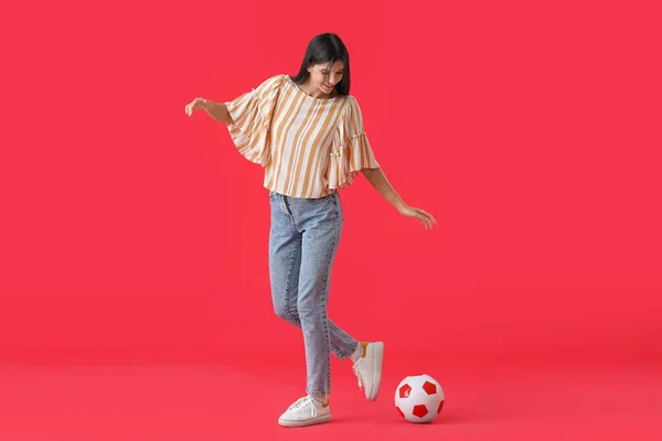 Mladá Žena Hraje Fotbalovým Míčem Červeném Pozadí — Stock fotografie