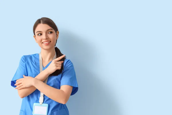 Female Medical Intern Pointing Something Blue Background — Photo