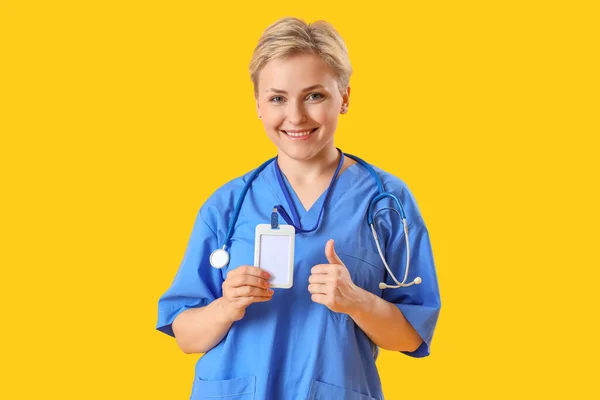 Жіночий Медичний Інтерн Значком Показує Великий Палець Жовтому Тлі — стокове фото