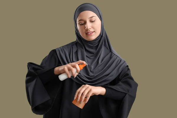 緑の背景に日焼け止めクリームを適用する若いイスラム教徒の女性 — ストック写真