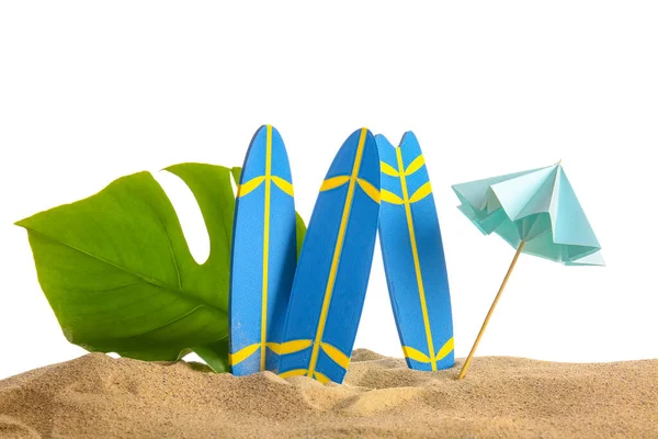 白い背景に砂の上に傘とヤシの葉を持つミニサーフボード — ストック写真