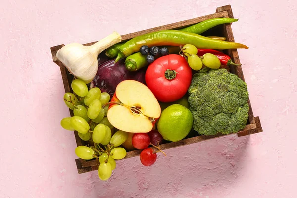 stock image Wooden box with different fresh fruits and vegetables on pink background