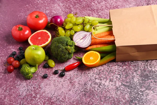 紫色の背景に新鮮な果物や野菜の異なる紙袋 — ストック写真