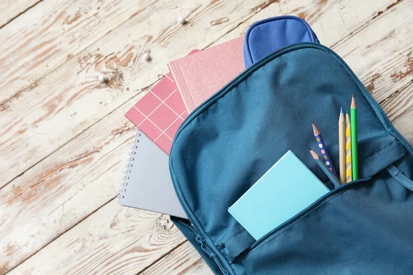 Μπλε Σχολική Τσάντα Πλάτης Σημειωματάρια Και Μολύβια Ξύλινο Φόντο — Φωτογραφία Αρχείου