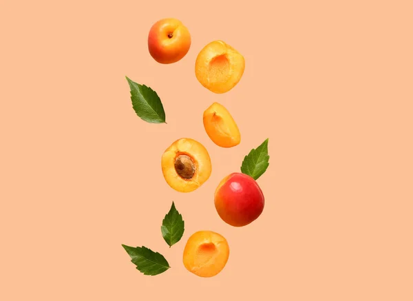Flying Fresh Apricots Pieces Leaves Orange Background — Stock Photo, Image