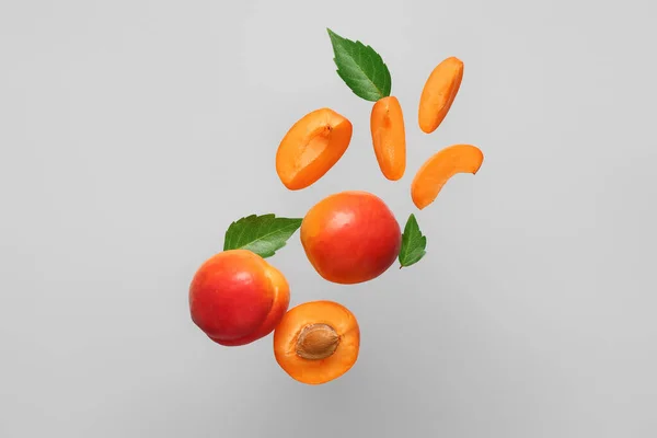Flying Fresh Apricots Pieces Leaves Grey Background — Stock Photo, Image