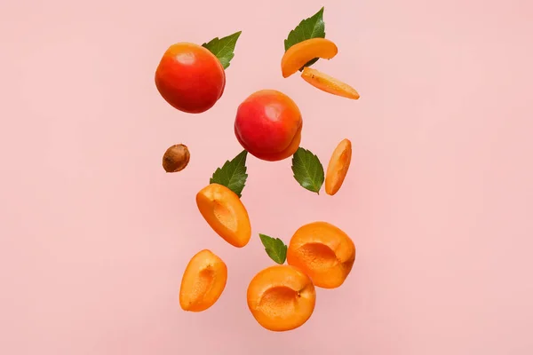 Flying Fresh Apricots Pieces Leaves Pink Background — Stock Photo, Image