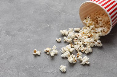 Gri arka planda lezzetli patlamış mısır kovası