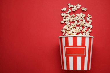 Kırmızı arka planda lezzetli patlamış mısır kovası