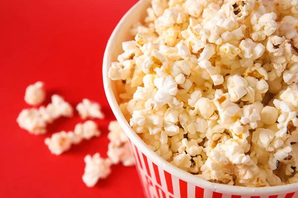 stock image Bucket with tasty popcorn on red background, closeup