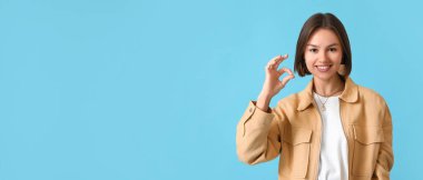 Açık mavi arkaplanda metin için boşluk gösteren genç bir kadın