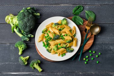 Koyu ahşap arka planda lezzetli makarna ve brokoli tabağı.