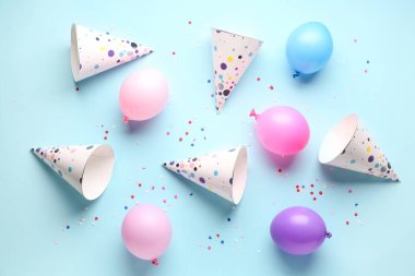 Parti şapkaları ve balonlar soluk mavi arka planda