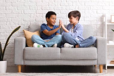 Evde birbirlerine beşlik çakan sevimli çocuklar.