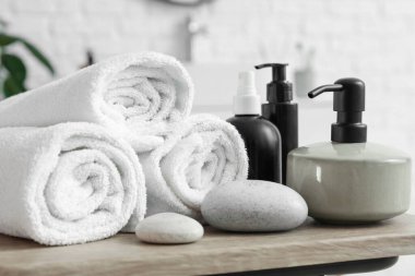 Sabun makinesi, çakıl taşları ve havlular banyoda masanın üstünde, yakın plan.
