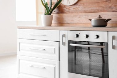 Ahşap duvarın yanında tenceresi olan modern elektrikli fırın.