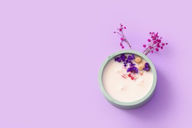 Mumlu tutucu ve leylak arkaplanda çiçekler