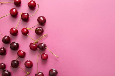 Pembe arka planda bir sürü tatlı kiraz
