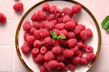 Taze ahududu tabağı ve pembe fayanslı nane şekeri.